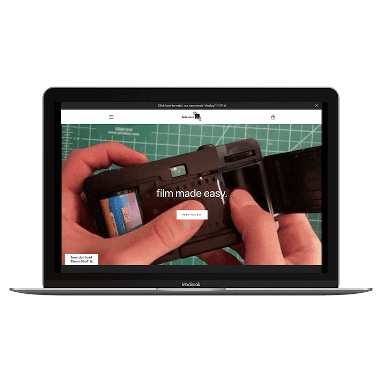 MacBook displaying a website showing hands loading 35mm film into a camera with text 'film made easy.'
